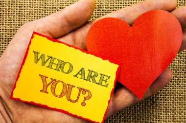 Kim sana soru gösteren el yazısı metin. İş kavramı Kişilik kimlik profili, hakkında Me veya yapışkan not kağıt ile kalp tutan el parmak ile yazılı You için.