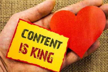 İçerik kral olduğunu gösteren el yazısı metin. Online pazarlama bilgi yönetimi ile cms veya Seo yapışkan not kağıt ile kalp tutan el parmak üzerinde yazılı veri için iş kavramı.