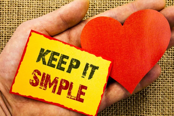 A kézírás szöveg mutatja, eltartás ez egyszerű. Üzleti koncepció egyszerűség egyszerű stratégiai megközelítés elvét Sticky Megjegyzés papír a szív gazdaság kéz ujjával írt. — Stock Fotó