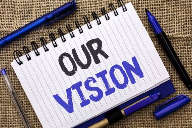 Kavramsal el bizim vizyon gösterilen yazma. Yenilik stratejisi görev hedef planı rüya amaç defter kitap jüt üzerinde yazılı yön vitrine iş fotoğraf kalemler yanında arka plan.