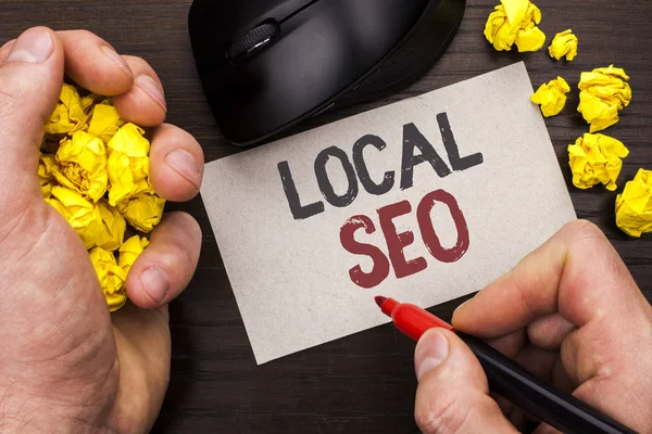 Menulis catatan yang menunjukkan Seo Lokal. Foto bisnis yang menampilkan Search Engine Optimization Strategy Optimize Local Find Keywords ditulis oleh Man on Note Paper Holding Marker pada latar belakang Wooden Mouse . — Stok Foto