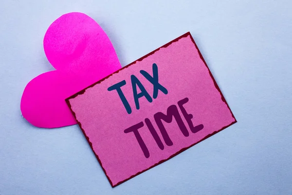 Escribir nota que muestra la hora de impuestos. Foto de negocios mostrando Impuestos Plazo Finanzas Pago Contabilidad Pago Ingresos Ingresos escritos en Pink Sticky Note Paper on the Plain background with Heart . — Foto de Stock