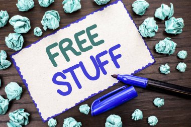 Free Stuff gösterilen not yazma. Tamamlayıcı ücretsiz, maliyet Chargeless Gratis maliyet gerektirmeyen karton parçası üzerinde ahşap arka plan Marker yanındaki yazılı ödenmemiş vitrine iş fotoğraf.