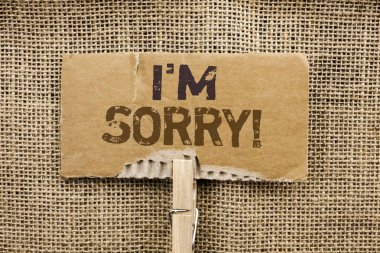 Writing note showing  I m Sorry. Business photo showcasing Apologize Conscience Feel Regretful Apologetic Repentant Sorrowful written on Cardboard Piece Holding By Clip on the jute background. clipart