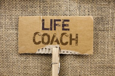 Yaşam koçu gösterilen not yazma. Mentorluk rehberlik Kariyer rehberlik teşvik eğitmen karton parça Holding tarafından klibin üzerine jüt arka plan üzerinde yazılı akıl hocası vitrine iş fotoğraf.