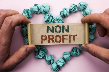 Word metin yazma kar amacı gütmeyen. İş kavramı için hayırsever Wrothless hayırseverlik yardım Unlucrative kağıt karton tutan adam düz arka plan kalp kağıt topları tarafından yazıldı Profitless.
