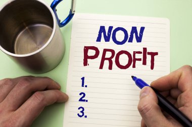 Kar amacı gütmeyen gösterilen not yazma. Hayırsever Wrothless hayırseverlik yardım Unlucrative adam tarafından defter kağıt tutan işaretçisi üzerinde düz arka plan Kupası üzerinde yazılı Profitless vitrine iş fotoğraf.