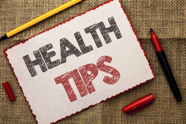 Writing note showing  Health Tips. Business photo showcasing Healthy Suggestions Suggest Information Guidance Tip Idea written on Cardboard Piece on the jute background Markers next to it.