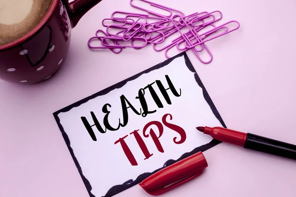 Text sign showing Health Tips. Conceptual photo Healthy Suggestions Suggest Information Guidance Tip Idea written on Sticky Note Paper on the plain background Marker Cup Pins next to it.