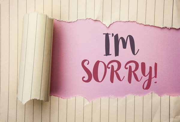 Writing note showing  I m Sorry. Business photo showcasing Apologize Conscience Feel Regretful Apologetic Repentant Sorrowful written on the pink background behind Tear Notebook Paper.