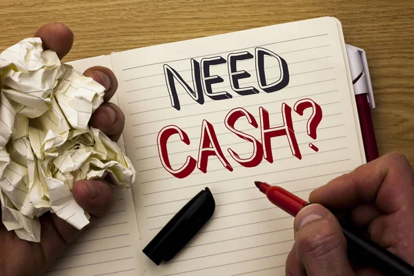 Handwriting text Need Cash Question. Concept meaning Wealth Question Needy Currency Money Advice Conceptual written by Man on Notebook Book Holding Marker on the wooden background Pen next to it.