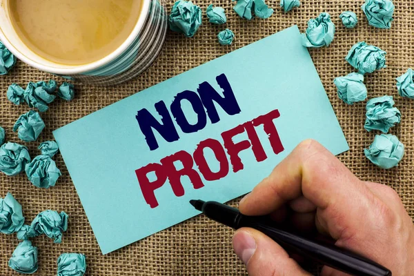 Skrivning notat viser Non Profit. Business foto fremvisning Velgørende Wrothless Filantropi Aid Ulukrativ Profitless skrevet af Man Holding Pen på Sticky Note Paper jute baggrund Cup - Stock-foto