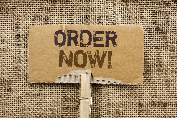Writing note showing  Order Now. Business photo showcasing Buy Purchase Order Deal Sale Promotion Shop Product Register written on Cardboard Piece Holding By Clip on the jute background.