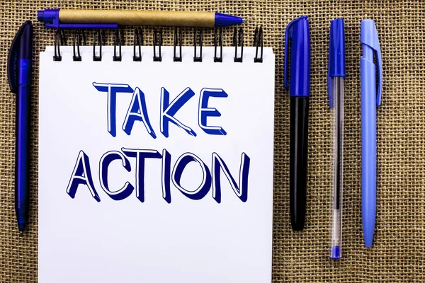 Writing note showing  Take Action. Business photo showcasing Strategy Future Actions Procedure Activity Goal Objective written on Notebook Book on the jute background Pens next to it.