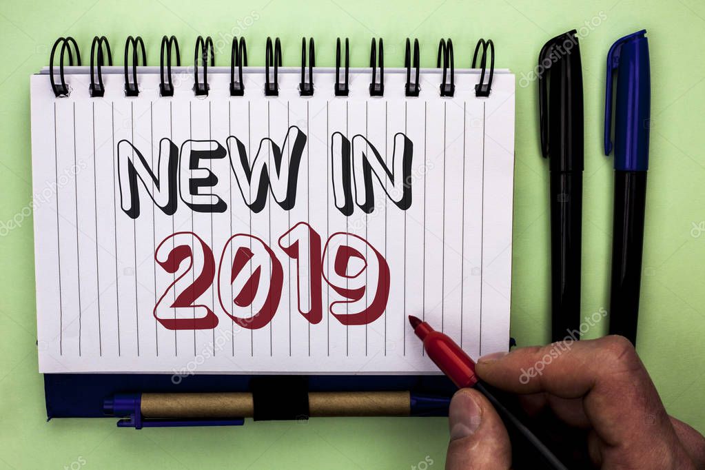 Writing note showing  New In 2019. Business photo showcasing Fresh Era Latest Year Period Season Annual Coming Modern written by Man Holding Marker on Nootbook Book plain background Marker.