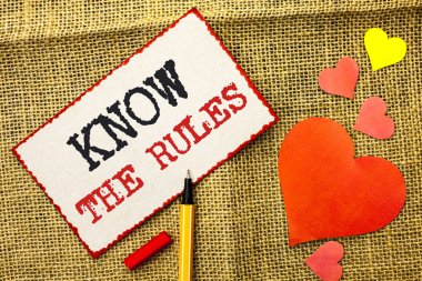 Handwriting text Know The Rules. Concept meaning Be aware of the Laws Regulations Protocols Procedures written on Sticky Note Paper by Pointer on the jute background Love Hearts next to it. clipart