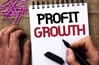Kar büyüme gösterilen metin işareti. Kavramsal fotoğraf finansal başarı artan gelirleri evrim Marker defter kitap jüt üzerinde arka plan Pins yanında Holding adam tarafından yazılmış geliştirme