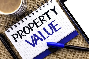 Özellik değerini gösteren metin işareti. Kavramsal fotoğraf tahmini, değer Emlak Konut defter kitap jüt arka planda Tablet kahve fincanı ve kalem yanında yazılı değerleme