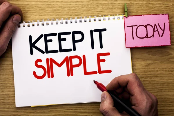 Word writing text Keep It Simple. Business concept for Simplify Things Easy Understandable Clear Concise Ideas written by Man on Notebook Book Holding Marker on the Wooden background Today.