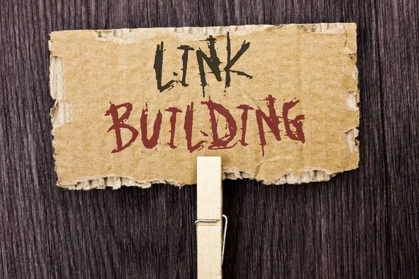 Woord schrijven tekst Link Building. Businessconcept voor het proces van het verwerven van hyperlinks uit andere websites verbinding geschreven op karton stuk houden met Clip op de houten achtergrond. — Stockfoto