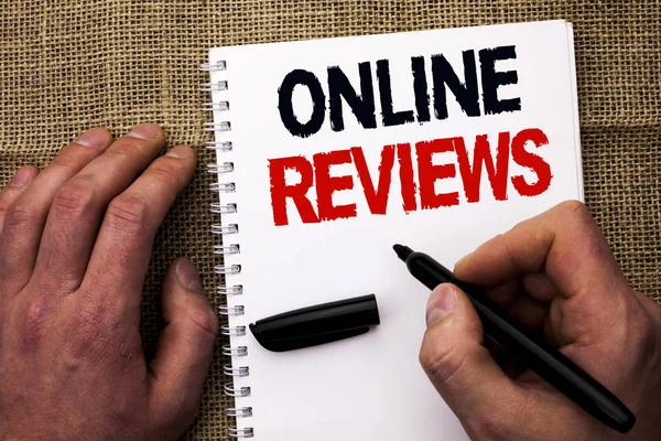 Handwriting text writing Online Reviews. Concept meaning Internet Evaluations Customer Rating Opinions Satisfaction written by Man Holding Marker on Notebook Book on the jute background.