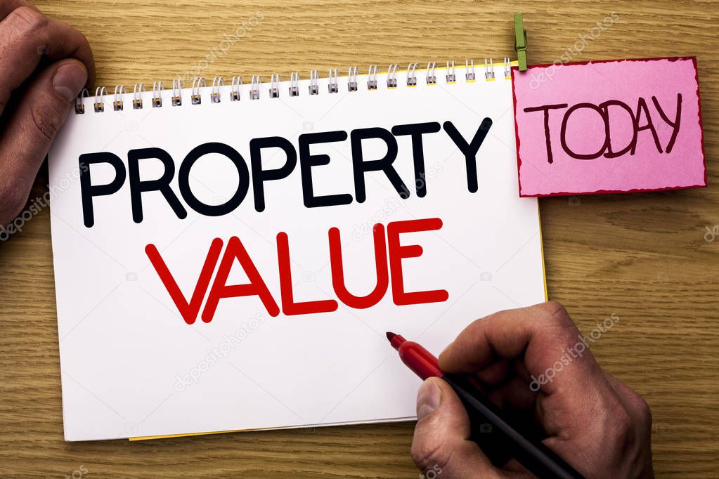 Word writing text Property Value. Business concept for Estimate of Worth Real Estate Residential Valuation written by Man on Notebook Book Holding Marker on the Wooden background Today.