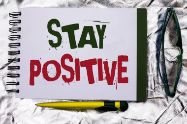 Kal olumlu gösterilen metin işareti. Kavramsal olarak iyimser motive iyi tutum ilham defter kitap dokulu arka plan üzerinde kalem ve gözlük ile yanındaki yazılı umutlu fotoğraf.