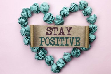 Writing note showing  Stay Positive. Business photo showcasing Be Optimistic Motivated Good Attitude Inspired Hopeful written on Cardboard Piece on Heart on the light pink plain background. clipart
