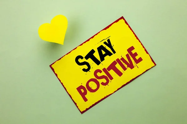 Scrittura di parole di testo Rimani positivo. Business concept for Be Optimistic Motivated Good Attitude Ispirato Speranzoso scritto su Yellow Sticky Note Paper sullo sfondo pianura Cuore accanto ad esso . — Foto Stock