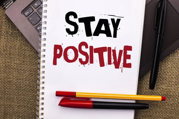 Пишу записку, показывающую "Оставайся позитивным". Будьте оптимистичны мотивированы хорошее отношение Вдохновленный Надежда написана на ноутбук Книга помещена на ноутбуке с джутом фоновые ручки — стоковое фото
