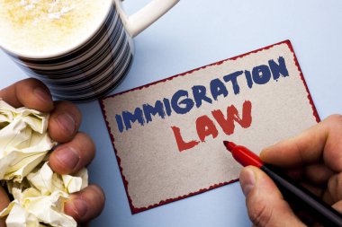 Göç yasası gösterilen not yazma. Adam tarafından karton parça Holding işaretçisi üzerinde düz arka plan üzerinde yazılı Göçmenler sınır dışı etme kuralları için ulusal düzenlemeler vitrine iş fotoğraf