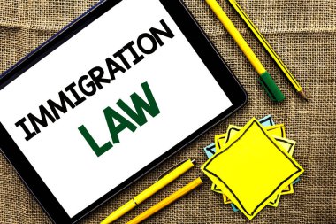 Göç yasası gösterilen metin işareti. Kavramsal fotoğraf ulusal düzenlemeler için Tablet kalem kalem jüt arka plan üzerinde ve yapışkan not kağıtları yazılı Göçmenler sınır dışı etme kuralları