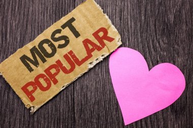 El yazısı metin en popüler. Üst puan Bestseller favori ürün veya sanatçı anlam kavramı aşk kalbi olan ahşap zemin üzerine karton parçası üzerinde yazılı sıralamasında 1.