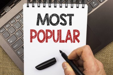 Metin yazma en popüler kelime. İş kavramı üst puan Bestseller favori ürün veya sanatçı için Notebook Laptop jüt arka plan ile yerleştirilen kitap adam tutarak Kalem tarafından yazıldı sıralamasında 1
