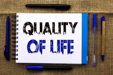 Kavramsal el yaşam kalitesini gösteren yazma. İş fotoğraf metin iyi yaşam tarzı mutluluk keyifli anlar defter kitap jüt üzerinde yazılı ruhsal sağlık kalemler yanında arka plan.