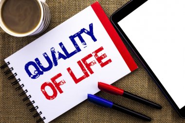 El yazısı metin yaşam kalitesi. İyi yaşam tarzı mutluluk keyifli anlar defter kitap jüt arka planda Tablet kahve fincanı ve kalem yanında yazılı ruhsal sağlık anlam kavramı.