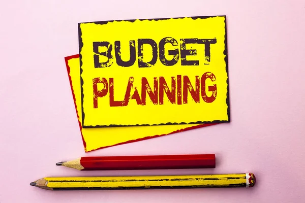 Znak textu zobrazující plánování rozpočtu. Konceptuální fotografie finanční Plannification hodnocení příjmů a výdajů, které jsou napsané na žluté lepkavé dopisní papír na růžovém pozadí s tužkou vedle ní. — Stock fotografie