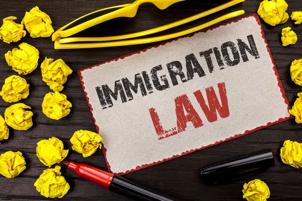 Conceptual hand writing showing Immigration Law. Business photo text National Regulations for immigrants Deportation rules written on Cardboard Piece on the wooden background Marker Glasses.