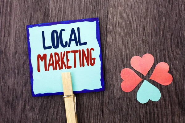 Handwriting text writing Local Marketing. Concept meaning Regional Advertising Commercial Locally Announcements written on Sticky Note Paper Holding With Clip on the wooden background Hearts.