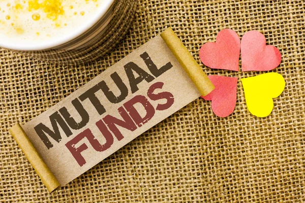 Writing note showing  Mutual Funds. Business photo showcasing Investment Strategy to purchase shares with other investors written on sticky Note on the jute background Love Hearts next to it.