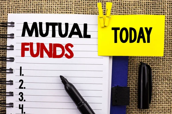 Word writing text Mutual Funds. Business concept for Investment Strategy to purchase shares with other investors written on Notebook book on jute background Today with Clip Marker next to it.