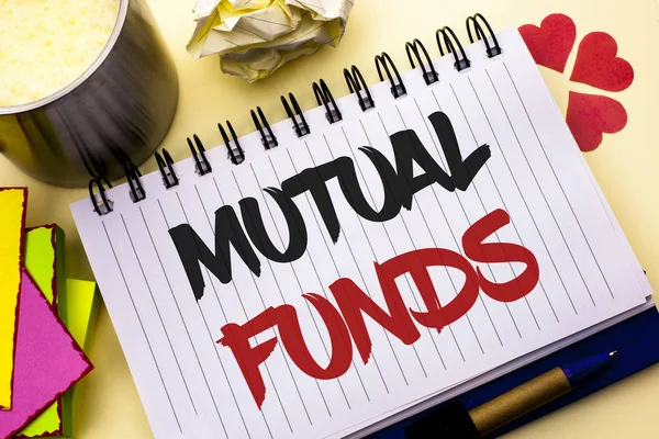 Writing note showing  Mutual Funds. Business photo showcasing Investment Strategy to purchase shares with other investors written on Notebook Book on the plain background Cup Pen Hearts
