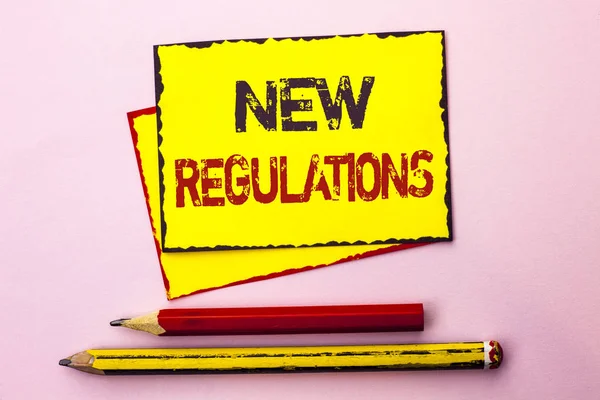 Text sign showing New Regulations. Conceptual photo Change of Laws Rules Corporate Standards Specifications written on Yellow Sticky Note Paper on the Pink background with Pencil next to it. — Stock Photo, Image