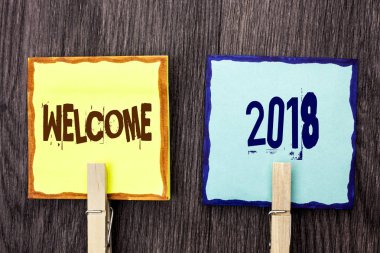 Word metin yazma hoş geldiniz 2018. İş kavramı kutlama yeni kutlamak gelecek tatminkar yapışkan not kağıtları tutan ahşap Klipsli ahşap arka plan üzerinde yazılı dilek için.