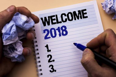 El yazısı metin hoş geldiniz 2018. Kutlama yeni kutlamak gelecek tatminkar adam tarafından Holding defter kitap ayracı düz arka plan üzerinde yazılı dilek anlam kavramı.