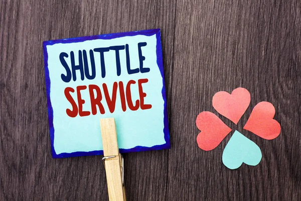Handwriting text writing Shuttle Service. Concept meaning Transportation Offer Vacational Travel Tourism Vehicle written on Sticky Note Paper Holding With Clip on the wooden background Hearts.