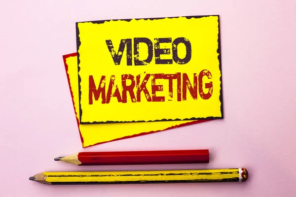 Szöveg jel mutatja a Video Marketing. Fogalmi fotó reklám multimédia támogatása digitális médiastratégia írt a sárga ragadós jegyzék könyv a rózsaszín háttér ceruzával mellette. — Stock Fotó