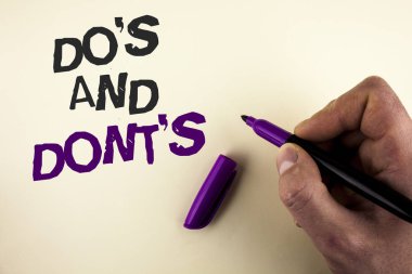 Conceptual hand writing showing Do'S And Don'Ts. Business photo showcasing What can be done and what cannot be knowing right wrong written by Man on plain background holding Marker in Hand. clipart