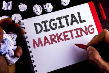 Writing note showing  Digital Marketing. Business photo showcasing Strategy of products services digital technologies online written by Man on Notepad holding Marker wooden background Paper Balls