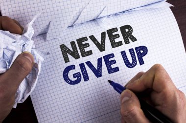 Word hiç Give Up metin yazma. İş kavramı için kalıcı kendinizi motive başarılı asla göz geri gözyaşı Nootbook Marker ahşap arka plan üzerinde tutarak kitap adam tarafından yazıldı.